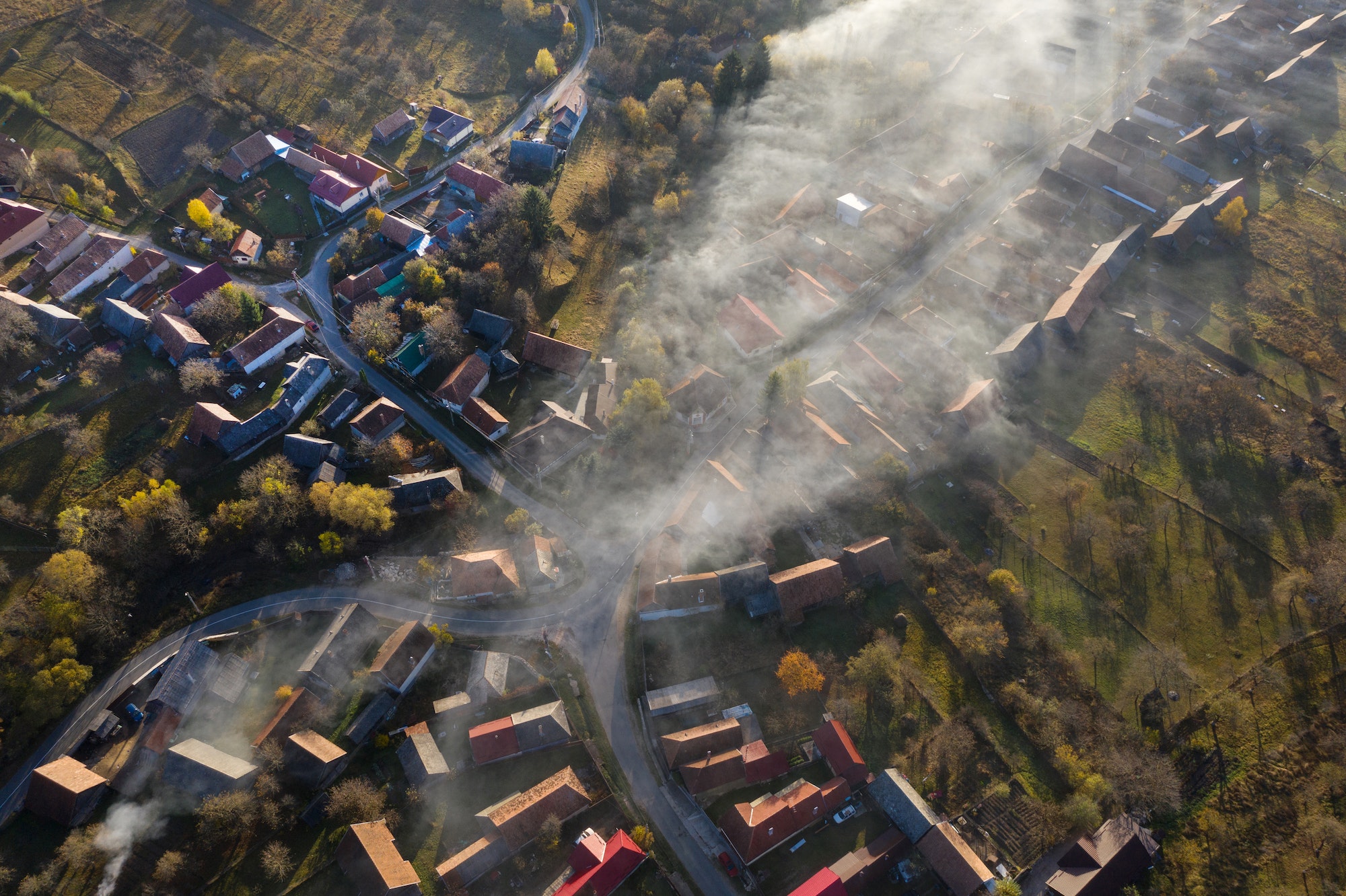Aerial drone view of morning haze and mist above village houses. Manastireni, Romania